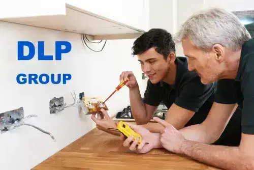 DLP Group electric technicians installing a wall socket.
